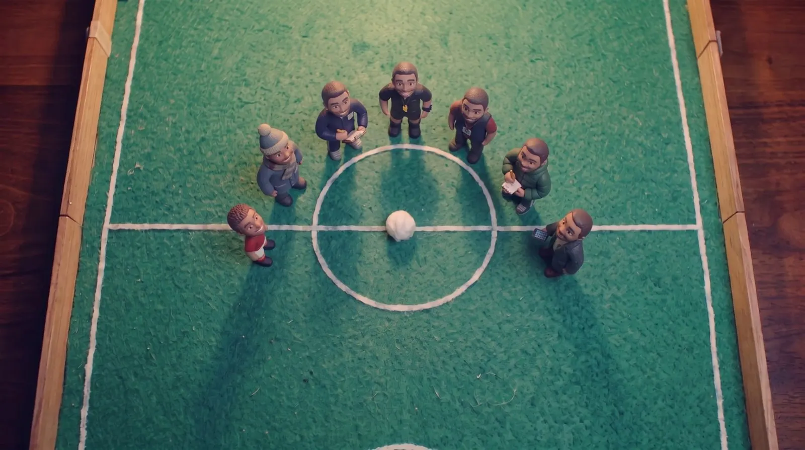 The whole cast standing round the centre circle, looking up